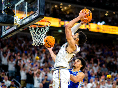 篮球比赛中球员完成空中接力扣篮的完美配合瞬间